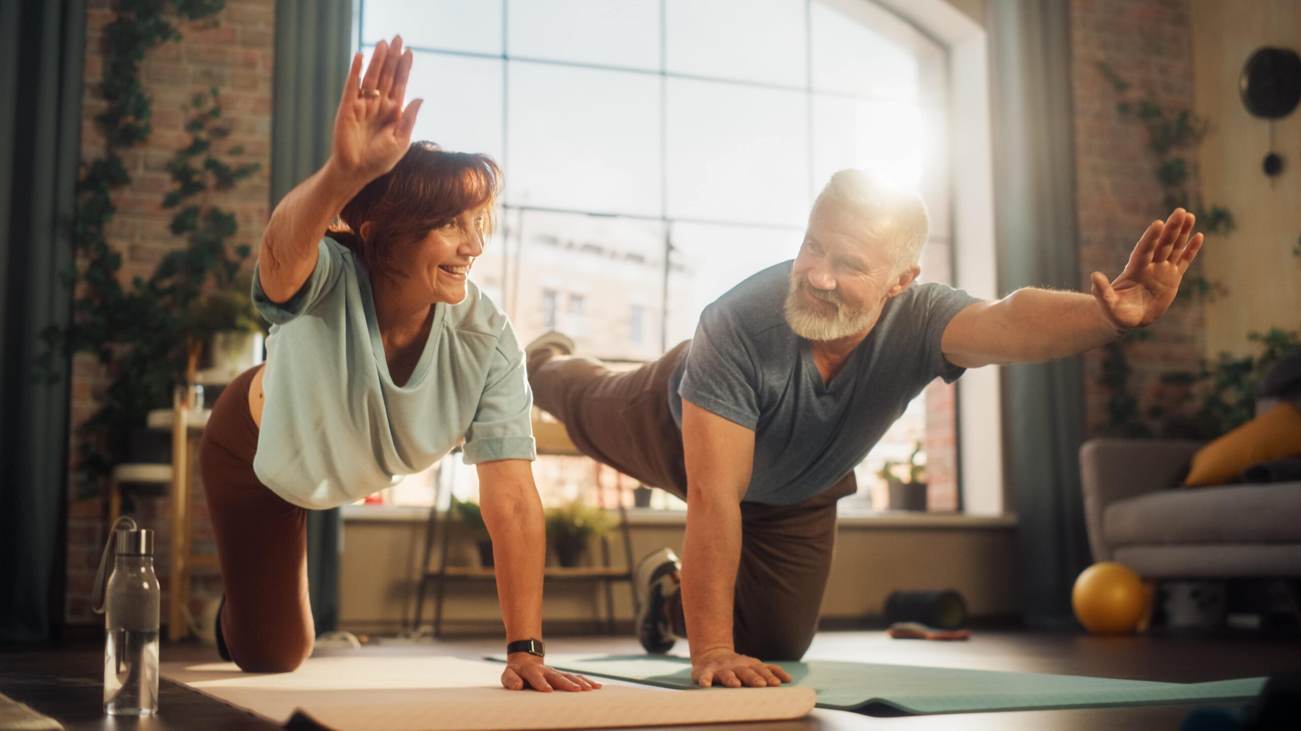 Happy Smiling Senior Couple Doing Gymnastics and Yoga Stretching Exercises Together at Amazonite Treatment Center